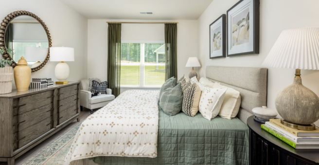 Bed with Blue Comforter and white pillows and sheets in a medium sized bedroom