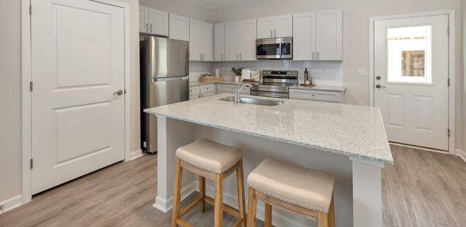 The Cottages at Capital Circle kitchen interior with large kitchen island, granite countertops and stainless steel appliances