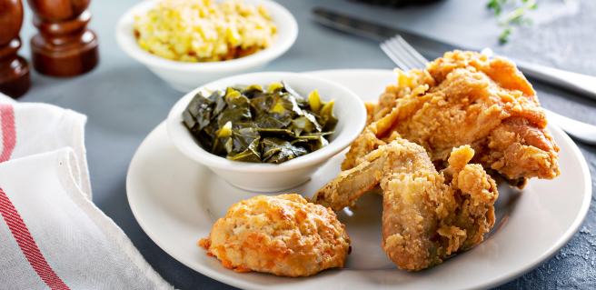 a plate of southern comfort food complete with fried chicken and collard greens